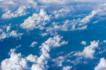 Cumuluswolken am blauen Himmel vom Flugzeugfenster aus gesehen