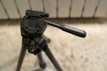 Tripod. Photography. Tripod adjustment. Hands are holding a tripod. Control levers. The kid takes...