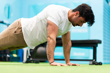 Fototapeta premium Strong man with tattoos training in the gym to compete