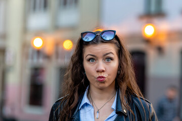 portrait of a cute and gorgeous women posing on blurred strret background with bokeh light