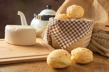Cheese bread, Brazilian breakfast arrangement, cheese bread, white cheese, kettle and accessories, dark abstract background, selective focus..