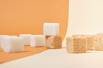 cane brown and white sugar cubes on beige background
