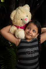 Teddy bear, Brazilian child playing with a lot of affection with his teddy bear, selective focus.