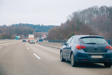 Fototapeta premium car driving on highway. Car on a highway that goes through forest. Autobahn in Germany 