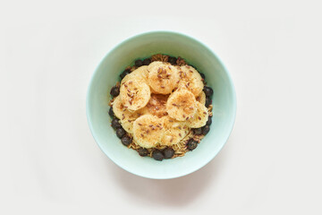 Healthy breakfast. Top view. Oatmeal with banana and flax seeds at bowl. Berry in plate. Organic meal recipe. Vegan cook. Minimalism granola. Hot porrigde with fruit