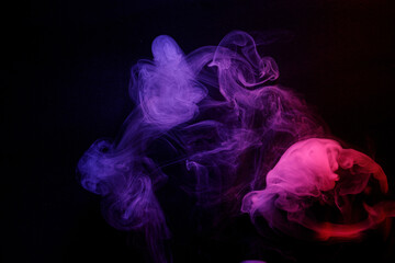 Abstract purple smoke moves on black background. Beautiful swirling smoke.