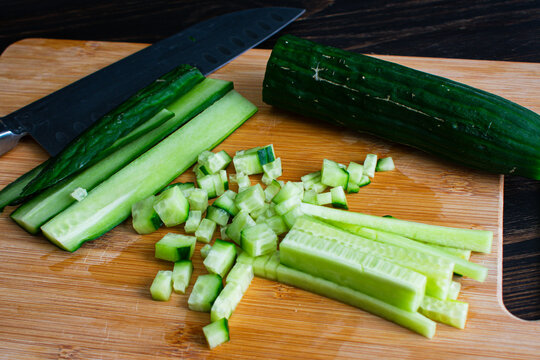 Dicing an English Cucumber with a Santoku Knife: Finely chopping an organic seedless cucumber on a bamboo cutting board