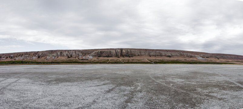 A parched lake that ends with mountains. The problem of climate change.