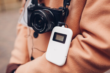 Tourist using wireless digital audio tour guide equipment with earphones. Man traveler goes sightseeing with camera