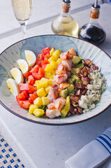 Cobb salad. Classic American restaurant or French bistro Cobb salad, made with chopped Bibb or Romain lettuce, heirloom tomatoes, bacon, blue cheese, avocado, hard boiled eggs tossed with olive oil.