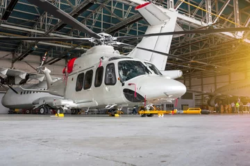 Papier Peint photo hélicoptère Hélicoptère de passagers et avions dans le hangar. Giravions et aéronefs en maintenance. Vérification des systèmes mécaniques pour les opérations aériennes