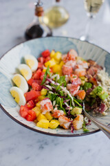 Cobb salad. Classic American restaurant or French bistro Cobb salad, made with chopped Bibb or Romain lettuce, heirloom tomatoes, bacon, blue cheese, avocado, hard boiled eggs tossed with olive oil.
