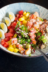 Cobb salad. Classic American restaurant or French bistro Cobb salad, made with chopped Bibb or Romain lettuce, heirloom tomatoes, bacon, blue cheese, avocado, hard boiled eggs tossed with olive oil.