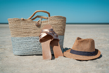  raffia bag on the beach with traw hat and sandals