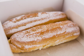 delicious French eclairs in a box with powdered sugar