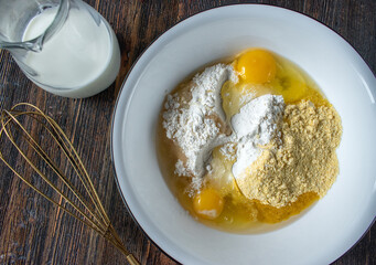 mixing bowl of flour and eggs batter for baking flat lay