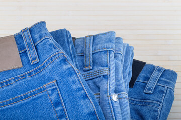 Three jeans in different blue shades on a light background.Selective focus.Concept of denim texture...