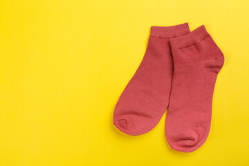 Top view of a pair of colored socks on a yellow background. Clothing in the form of socks.