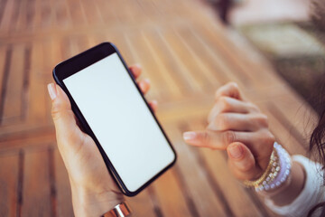 Stylish woman in shirt sitting at table using phone app