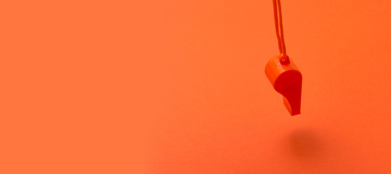 Orange Sports Whistle On Orange Background.Concept- Sport Compet