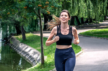 Running woman. Young woman jogging in the park. Workout in a park