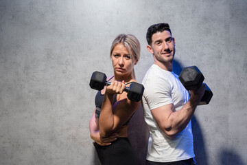 blonde girl and brunette boy training in the gym

