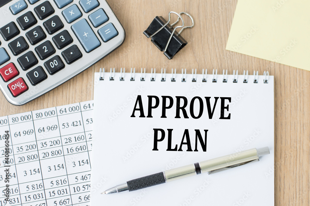 Poster notepad with text approve plan, next to it lies a calculator and yellow note papers. business concep