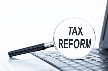 words TAX REFORM in a magnifying glass on a white background. business concept