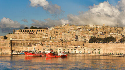 The sun rises over the bay in Valletta, Malta displaying vibrant colors