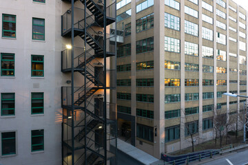 Urban residential building with outdoor black fire escape stairs in Brooklyn, New York