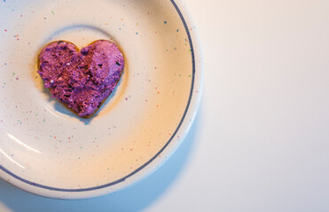 Heart shaped cookie spread with blueberry curd cream for Valentine's Day on plate on white table top view, Homemade sweet dessert photo with space for text