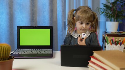 Back to school, online learning distance lesson education at home, technology for schoolgirl pupil. Child girl doing school homework and using tablet. Laptop with green screen at home. Slow motion