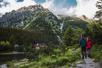 Couple on an evening walk around Popradske mountain lake during sunset