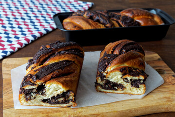 Braided cake with chocolate cut in half. Yeast-risen dough twisted krantz cake.