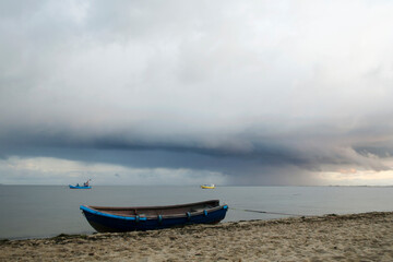 Szerokie ujęcie chmury cumulonimbus nad kutrami rybackimi na morzu