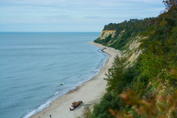 view from the heights on the Baltic Sea shore, a sandy beach and the edge of the forest against a gray cloudy sky in the Kaliningrad region