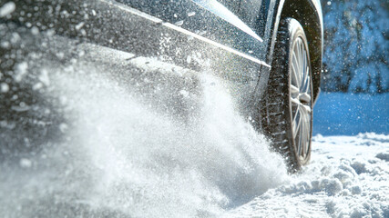 CLOSE UP, DOF: Fresh snow flies up from a large vehicle's spinning wheel. © helivideo