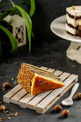 Deliciouse cake with chocolate cream, hazelnut and caramel dressing on the miniature wooden pallet. Traditional hungarian Dobos cake.
