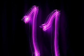 Long exposure photography. Writes 11 with pink light on black background. Neon lights wallpaper.