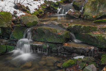Small creek near Zlata Koruna village with green moss stone in winter cold day