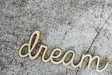 Mot Dream écrit en lettres de bois sur un arrière plan en béton griffé et espace vide
