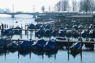 Lots of small boats side by side in a small city harbor. Lake in Switzerland. Boats for rent to tourists. Tourism in Europe 