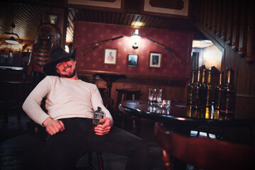 Obraz premium Cowboy smoking and drinking in a bar