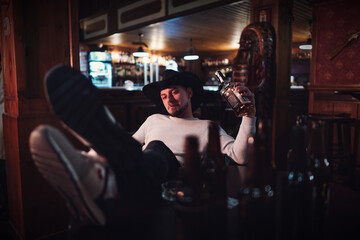 Cowboy smoking and drinking in a bar