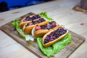 hot dogs with fried onions on lettuce leaves