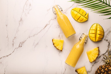 Tropical smoothie with pineapple and mango on marble background