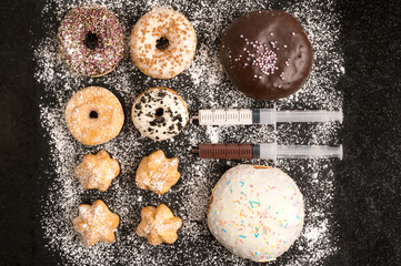 Fototapeta na wymiar Fresh homemade donuts, mini stuffed donuts, stuffed choux and two syringes