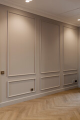 modern and bright interior of empty cream colored corridor with herringbone parquet floor