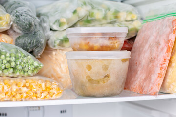 Frozen food in the freezer. Frozen soup, vegetables, ready meals in the freezer