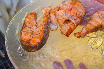 Grilled red fish trout steaks lie on a glass plate